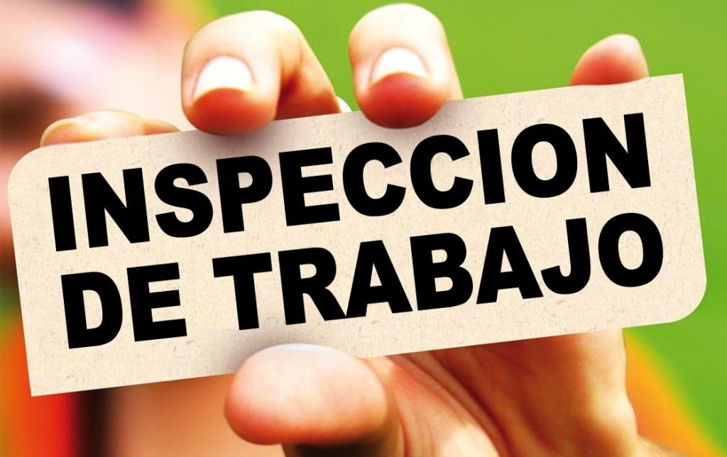 Imagen de una mano con un cartel donde se lee "Inspección de Trabajo"