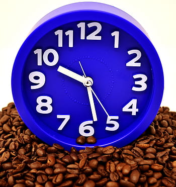 Imagen de un reloj sobre granos de café. Coffee Break.